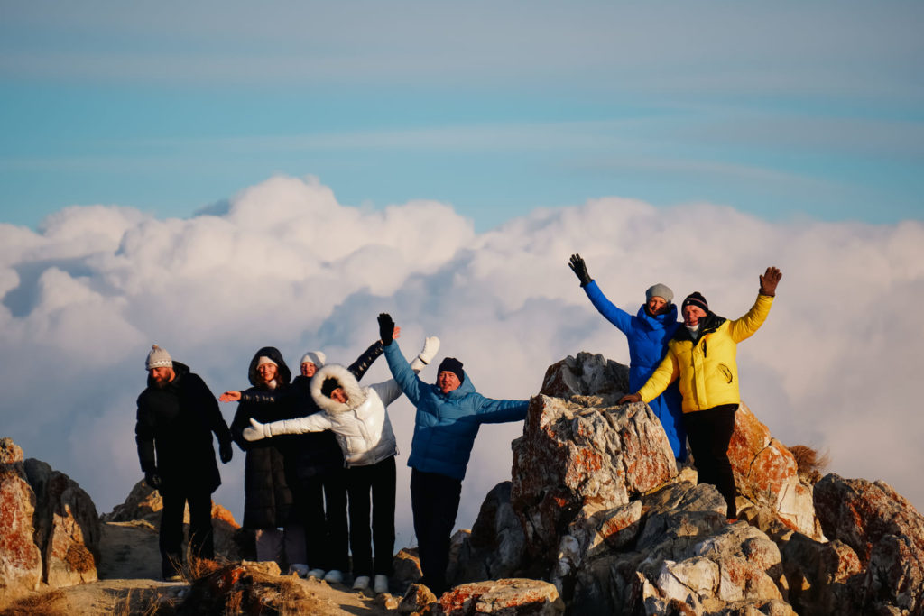 люди фотографируются на фоне облаков на байкале зимой