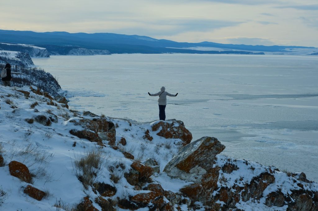 Человек фотографируется на Байкале зимой